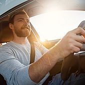 Lächelnder Mann beim Autofahren