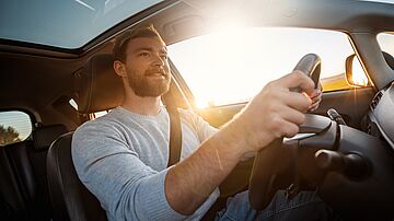 Lächelnder Mann beim Autofahren