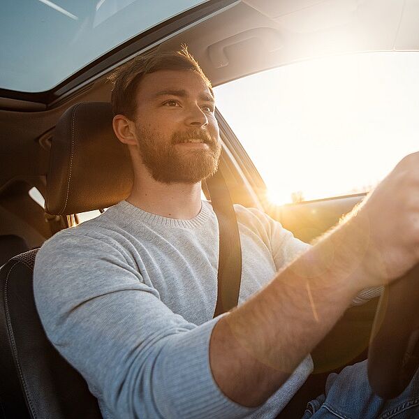 Lächelnder Mann beim Autofahren