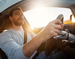 Lächelnder Mann beim Autofahren