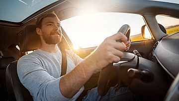 Lächelnder Mann beim Autofahren