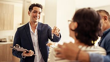 Vermieter übergibt Schlüssel an seine neuen Mieter