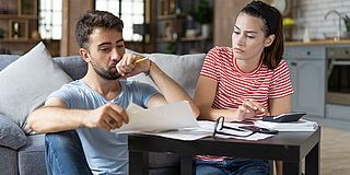 Junges Paar liest nachdenklich ein Schreiben