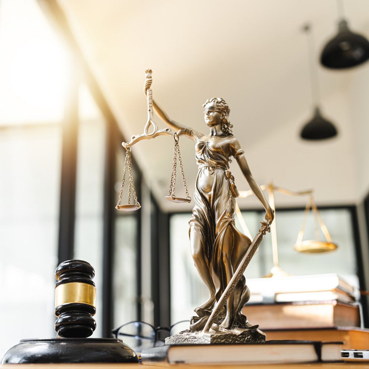 Justitia und Richterhammer auf Schreibtisch