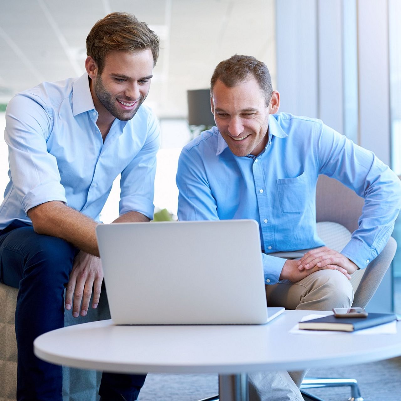 DEURAG Vertriebspartner Vertriebspartner beraten sich und schauen auf einen Laptop