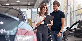 Autoverkäuferin und Käufer mit Checkliste
