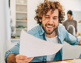 Selbstständiger sitzt am Tisch und hat vor sich Rechnungen liegen