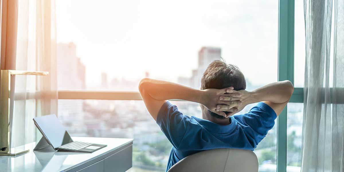Vorgetäuschte Arbeitsunfähigkeit: Mann schaut entspannt aus dem Fenster