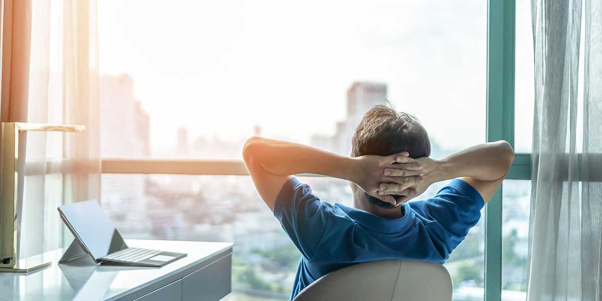 Vorgetäuschte Arbeitsunfähigkeit Vorgetäuschte Arbeitsunfähigkeit: Mann schaut entspannt aus dem Fenster