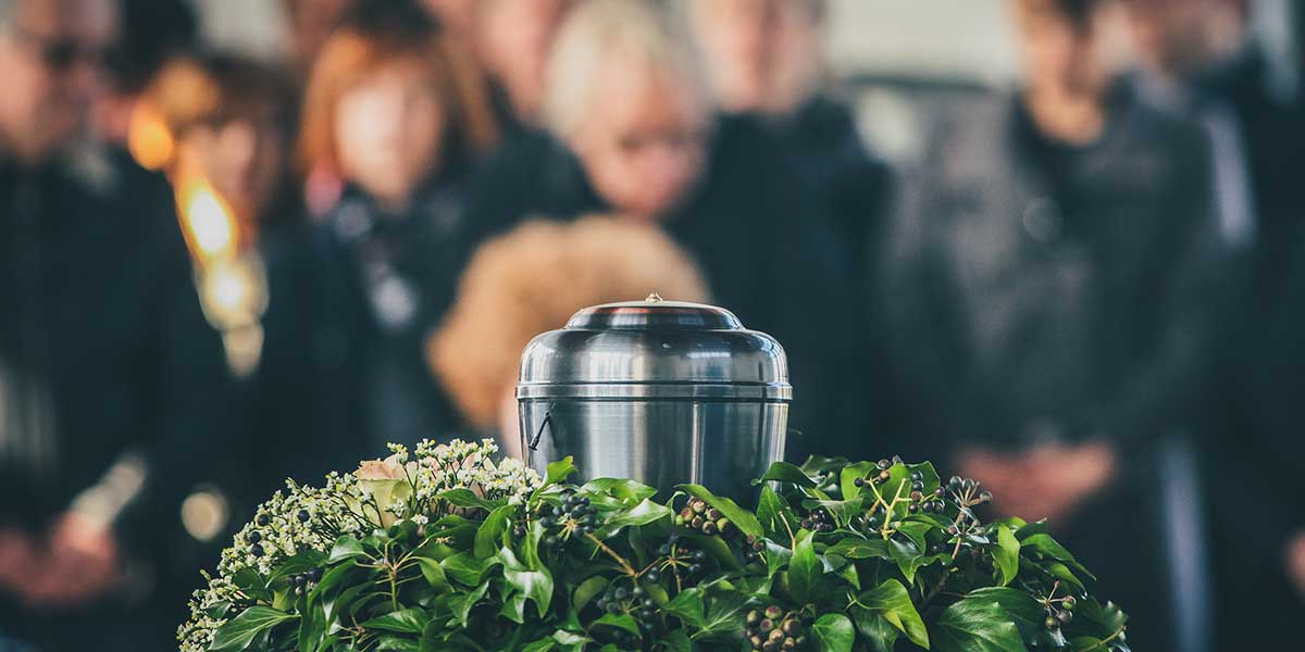 Beerdigungskosten - Urne vor Trauergemeinde