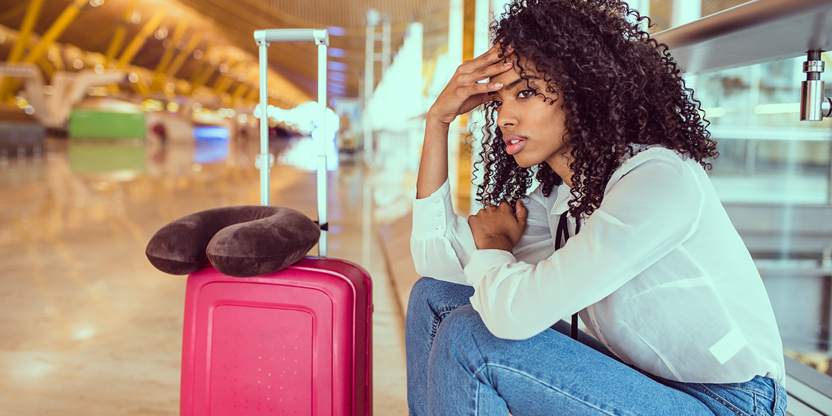 Reisemangel richtig reklamieren: Frau mit Gepäck auf dem Flughafen