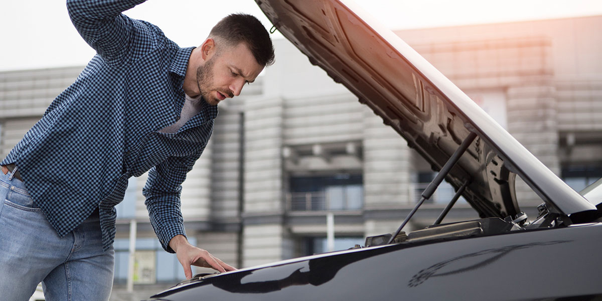 Mann prüft mangelhafte Reparatur am Auto - Gewährleistung?