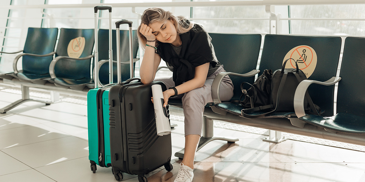 Frau mit Koffer wartet wegen Streik am Flughafen