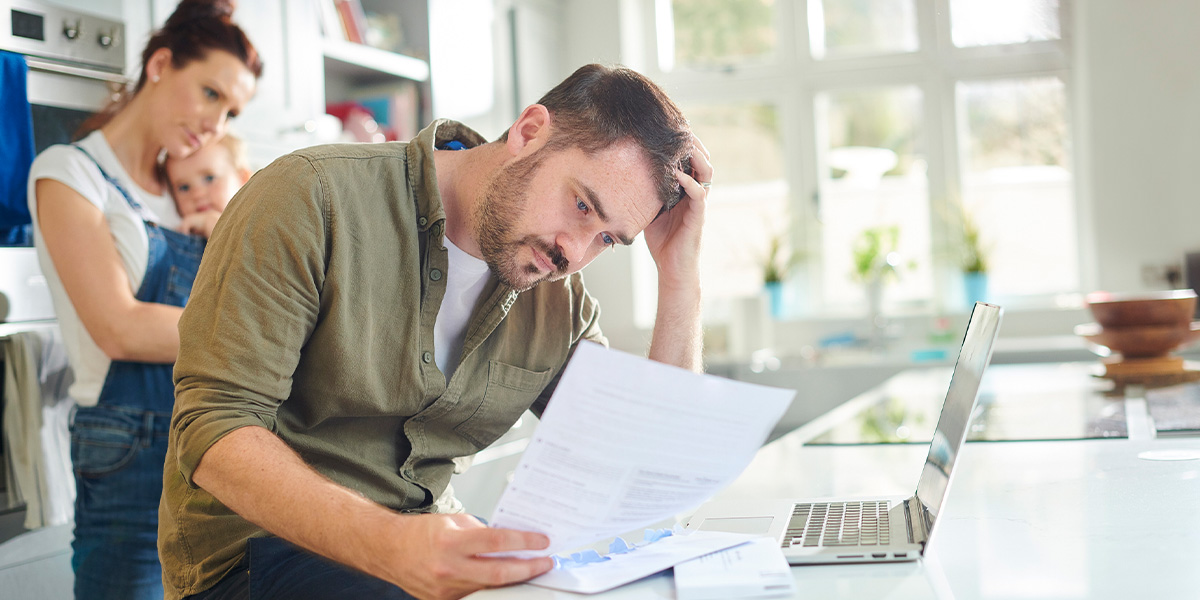 Elterngeld-Kürzung widersprechen Eltern über Elterngeld-Bescheid gebeugt